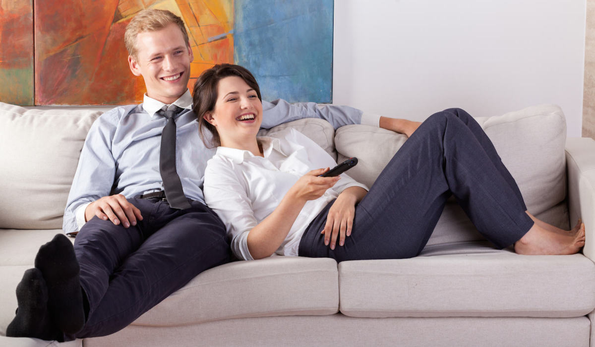 Busy couple watching tv after work